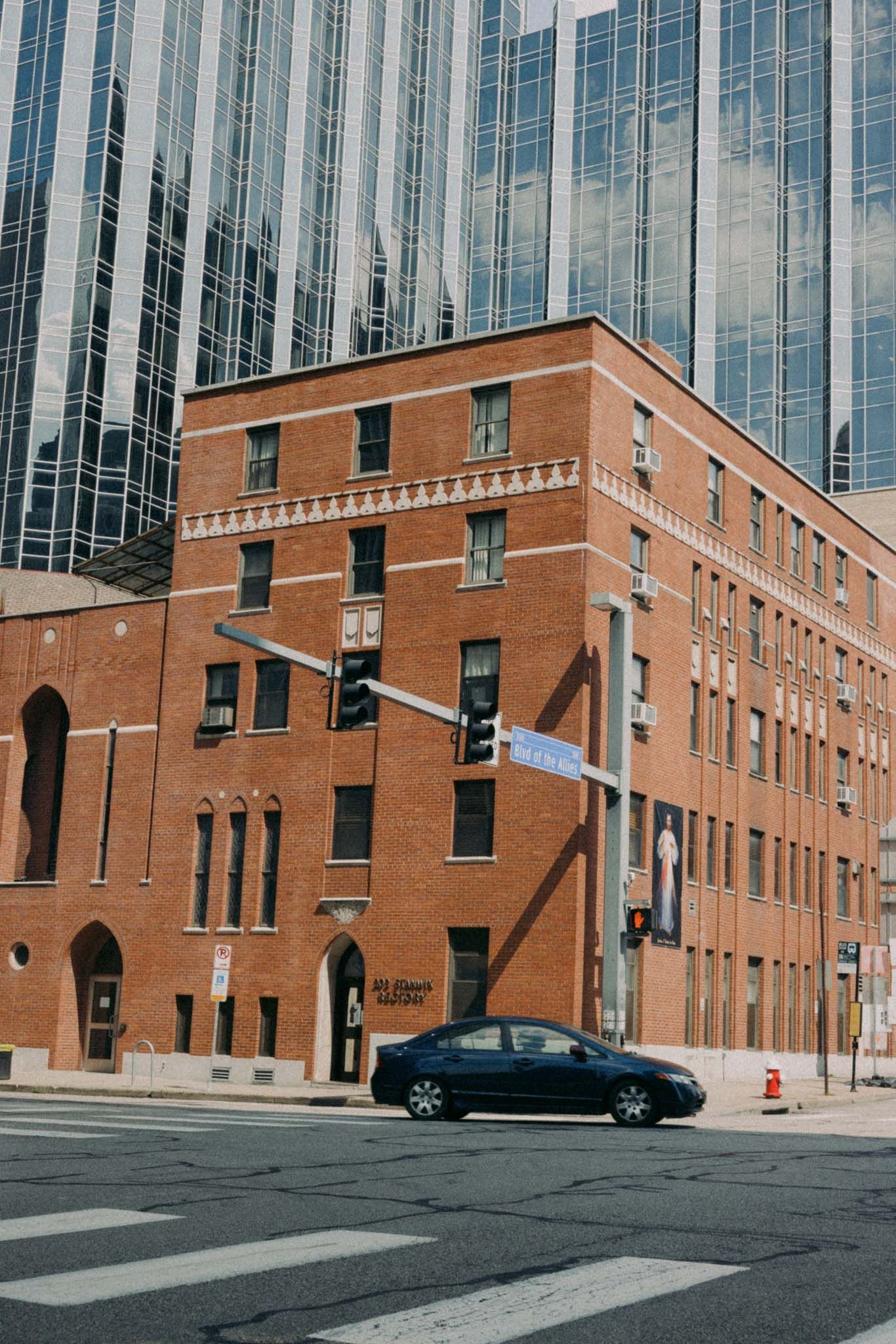 Street view of a brick and glass building with Gothic-style architectural details and modern design elements.