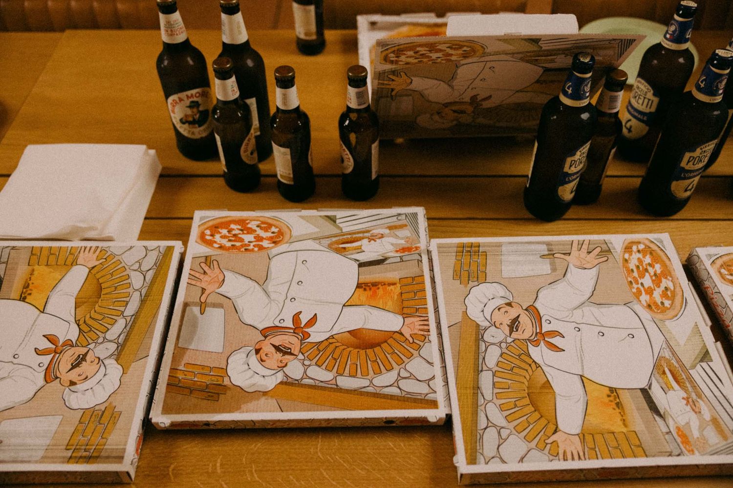 A series of sequential drawings and sketches laid out on a wooden table showing the progression of an animation project.