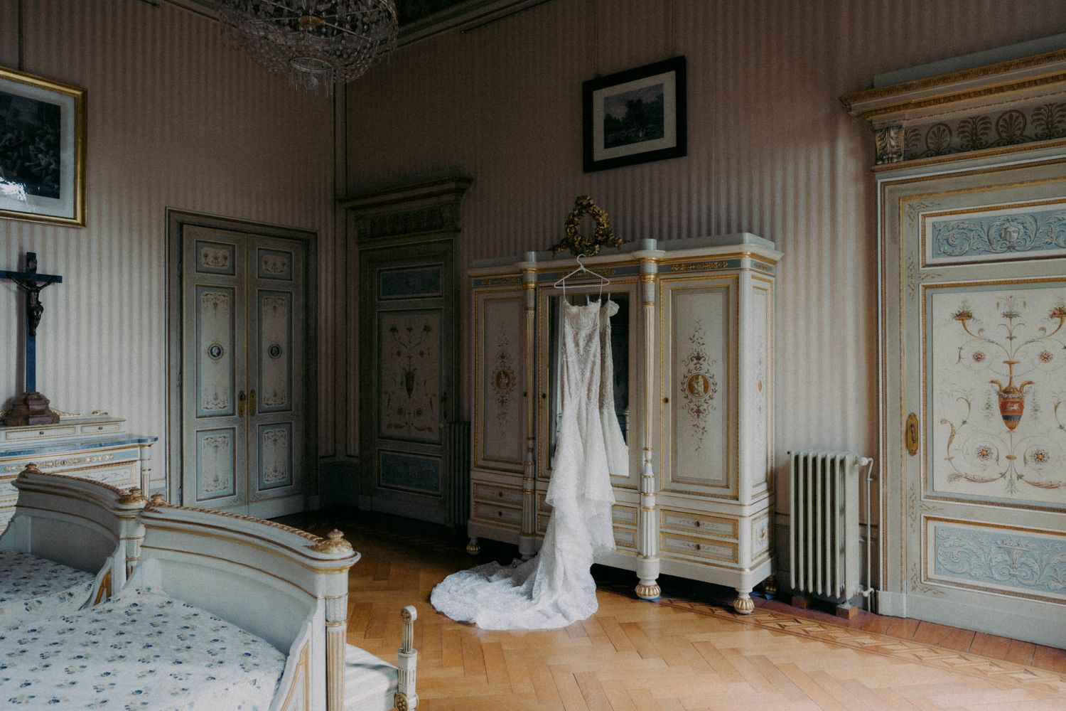 Elegant vintage French bedroom interior with ornate furniture, blue and gold decor, and white drapes.
