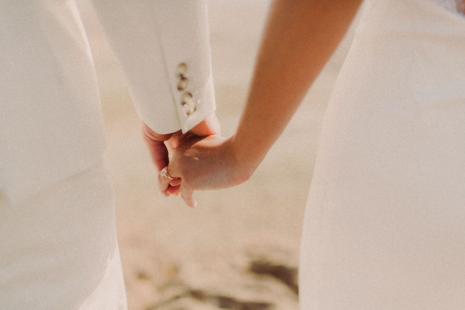 A close-up view of hands delicately folding a white paper origami creation.