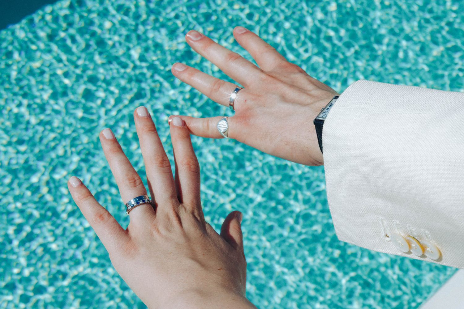 Hand placing white paper towels on a blue tiled surface to demonstrate cleaning technique.