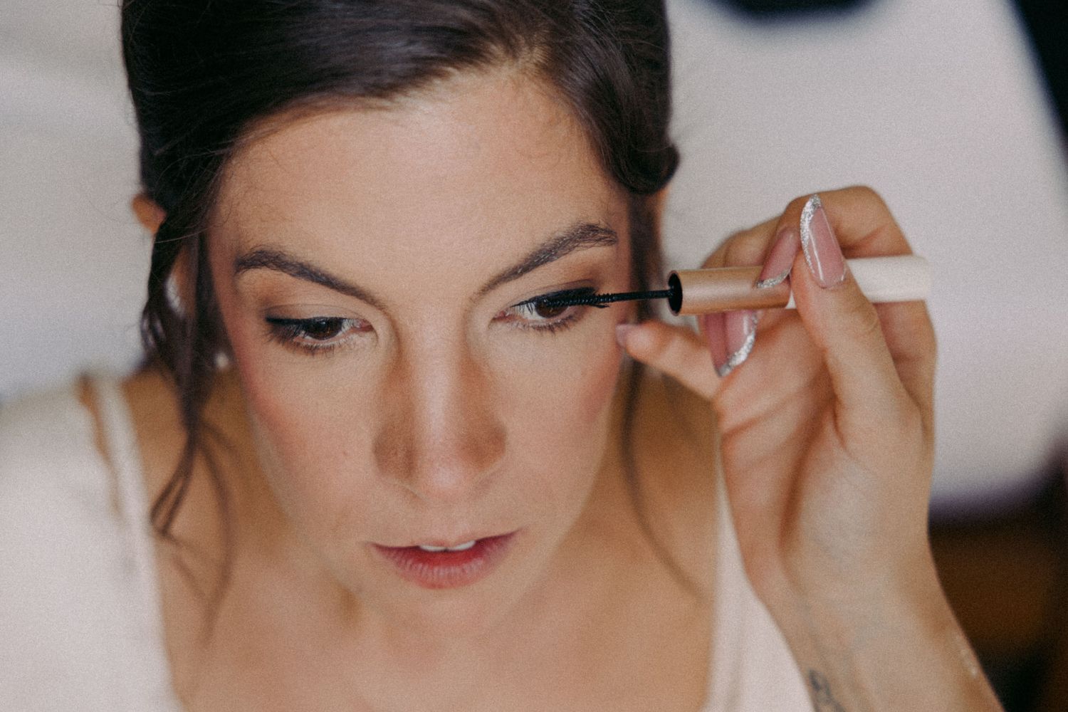 A collage of close-up shots showing professional makeup application with brushes and cosmetic tools.
