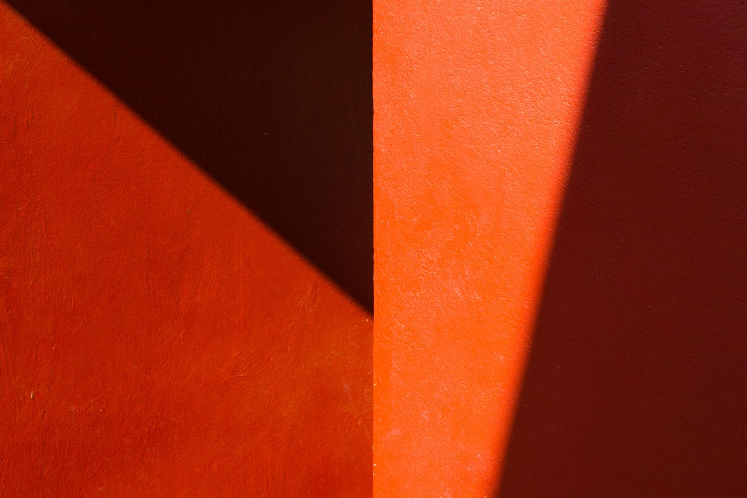 Red and black abstract diagonal lines create a striking geometric pattern with dramatic contrast and shadows.