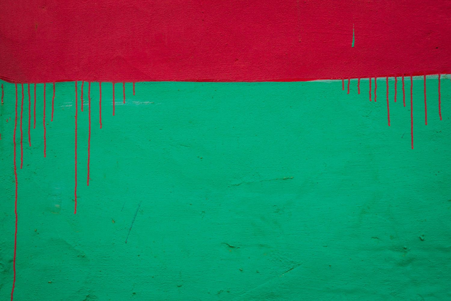Abstract art pattern featuring contrasting red and green colors with dripping paint effect along the edges.