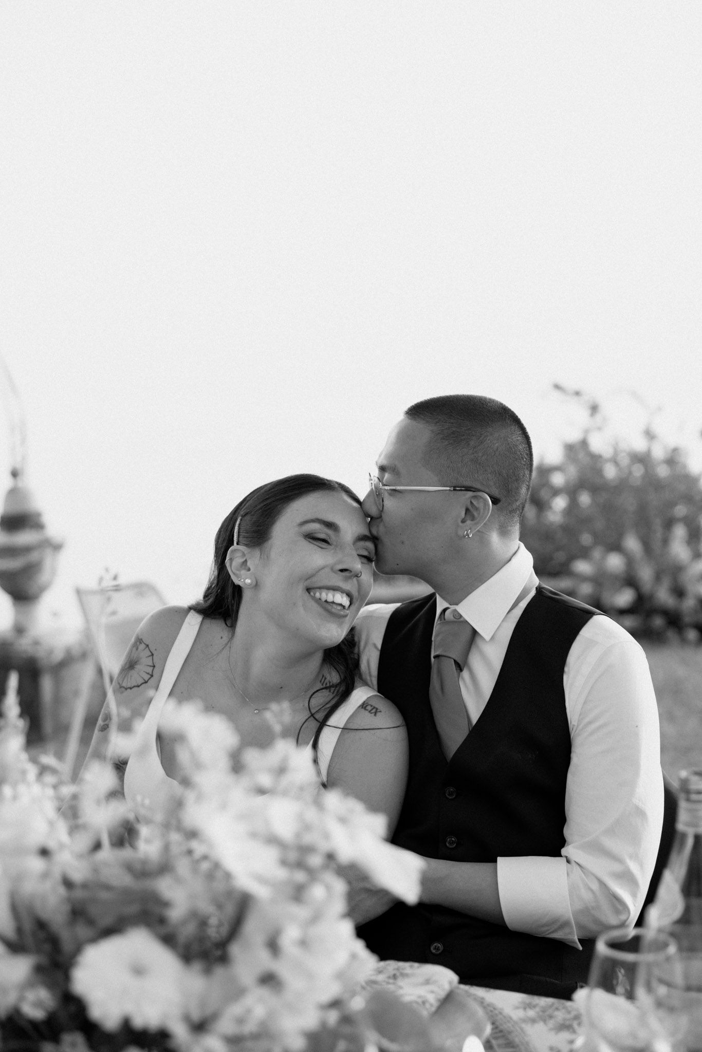 A romantic black and white photo sequence shows a couple sharing tender moments and embraces in an outdoor setting.