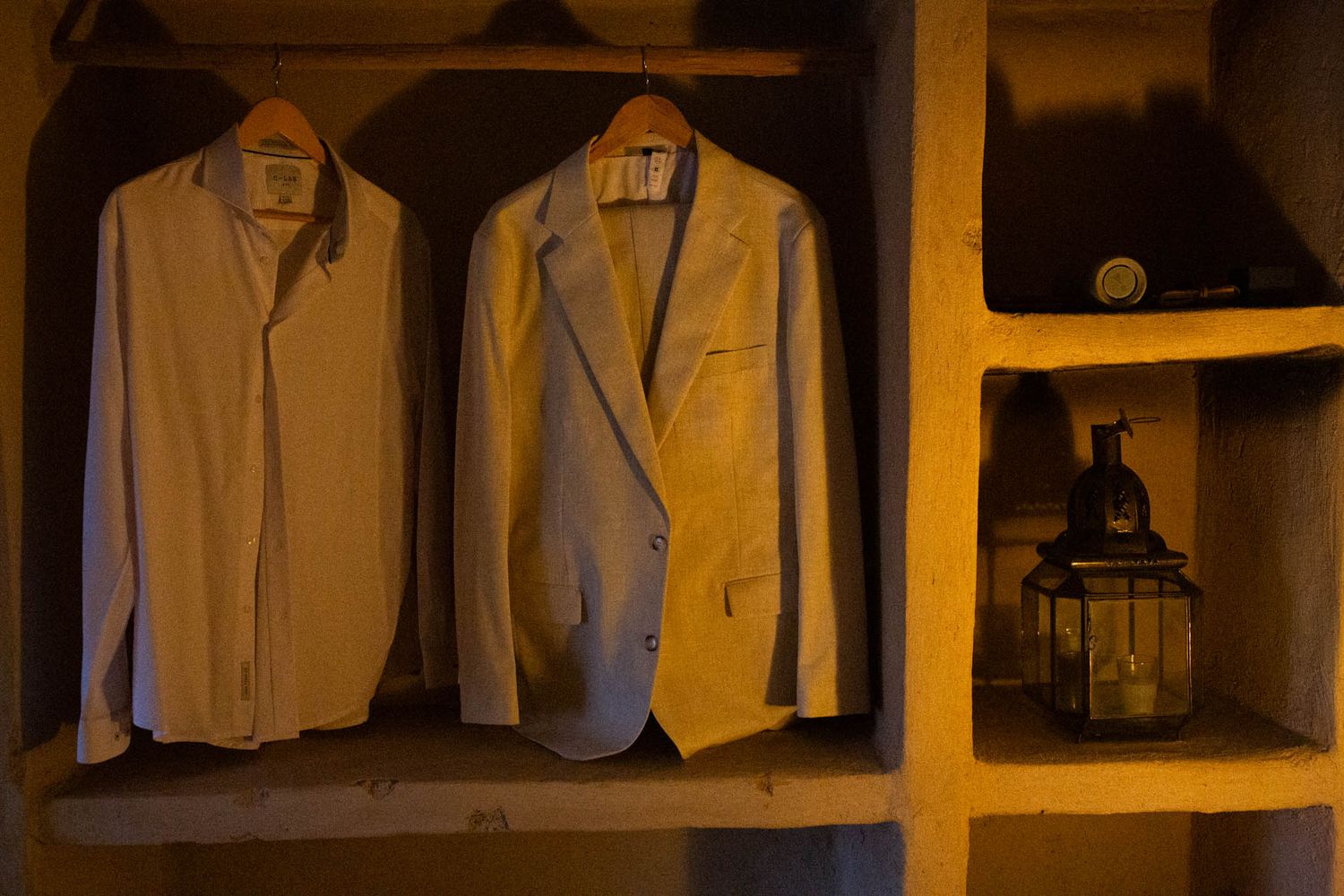 Rows of tailored white dress shirts and suits hang neatly displayed in an upscale clothing boutique.