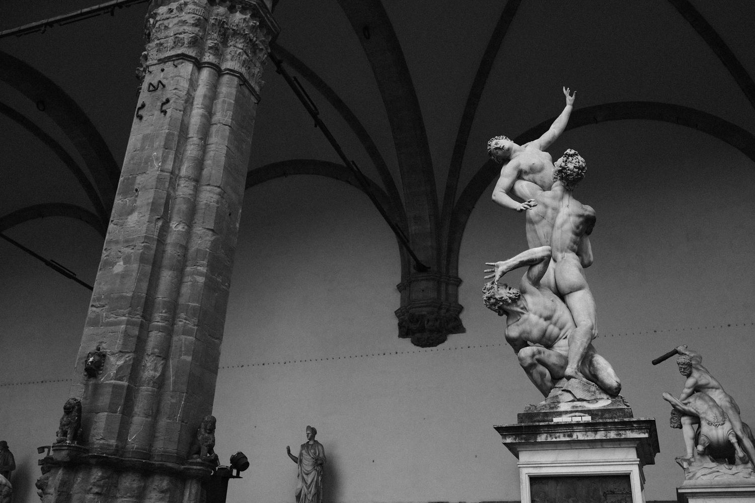 A series of black and white photographs showing a skateboarder performing tricks on a handrail near stone columns.