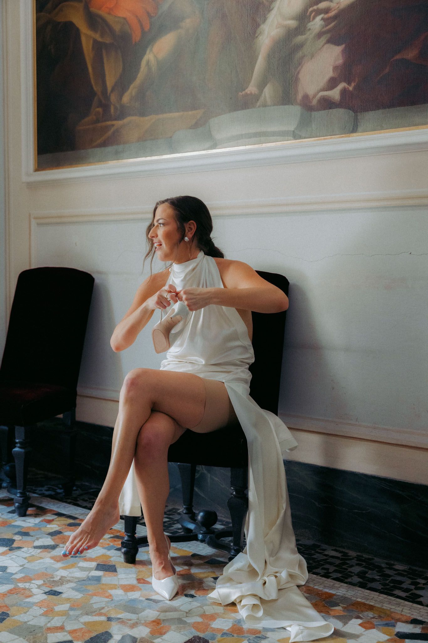 A series of artistic photos showing a person in white sitting on a tiled floor against a wall with decorative paintings.