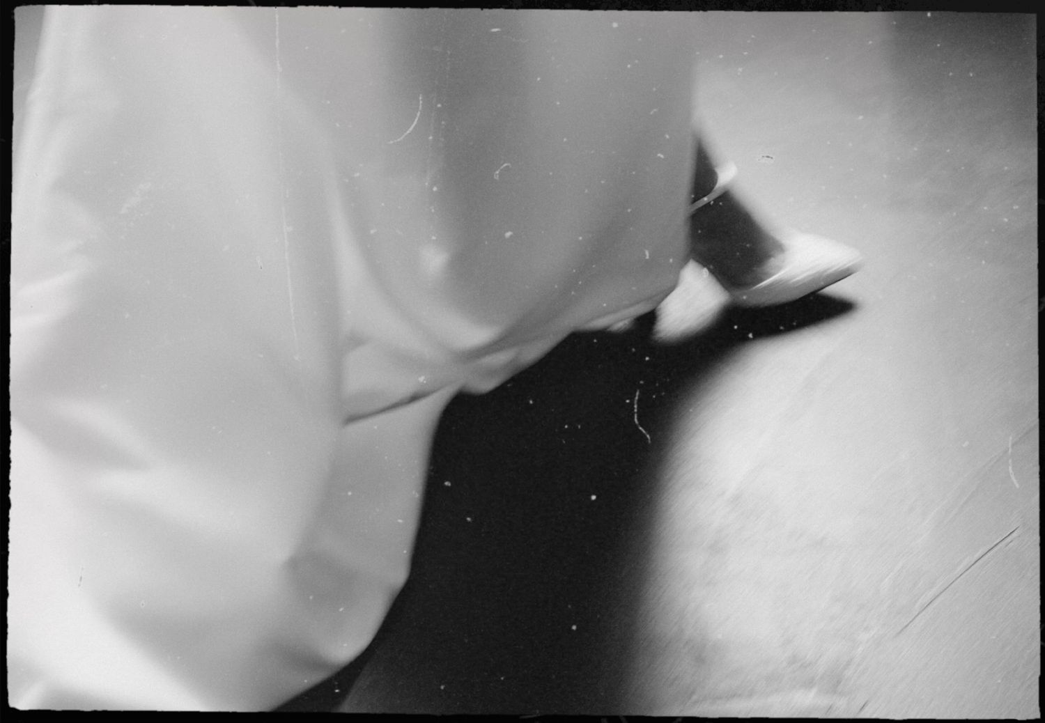 A series of abstract black and white photographs showing blurred shapes and shadows in a minimalist style.