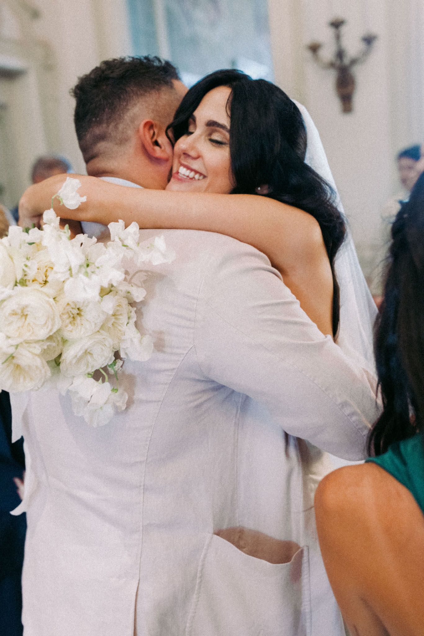 A romantic sequence of wedding photos showing a couple embracing with white flowers in view.
