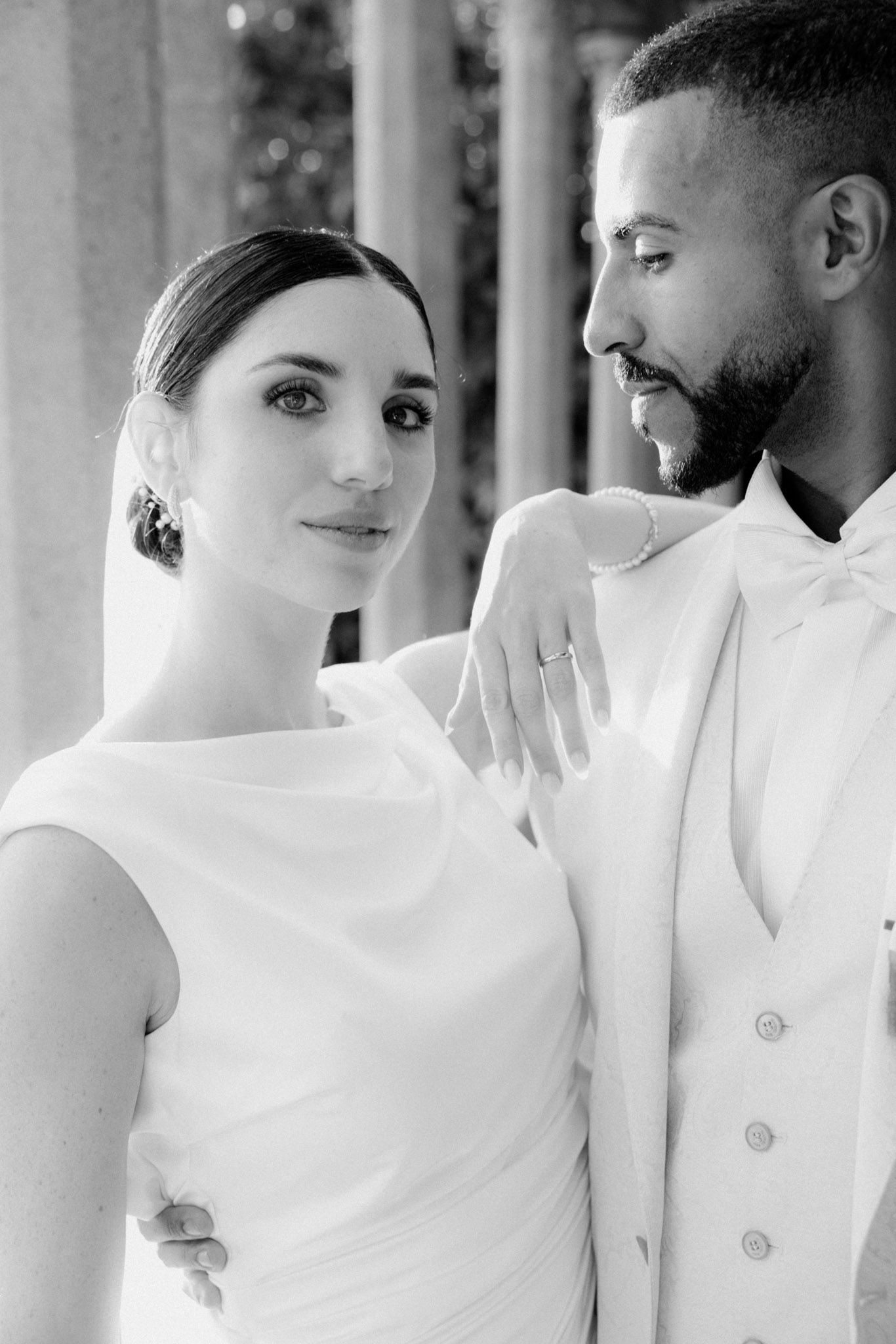 A series of intimate black and white wedding photos showing tender moments between a couple in white attire.