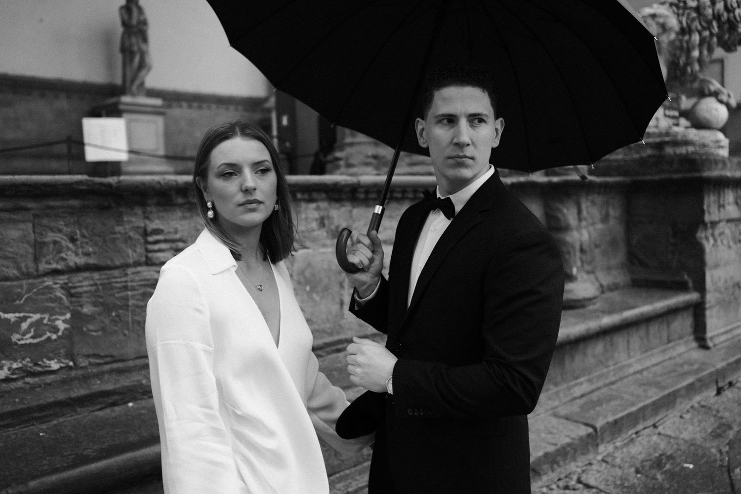 A series of black and white wedding photos showing romantic moments between a couple in formal attire.