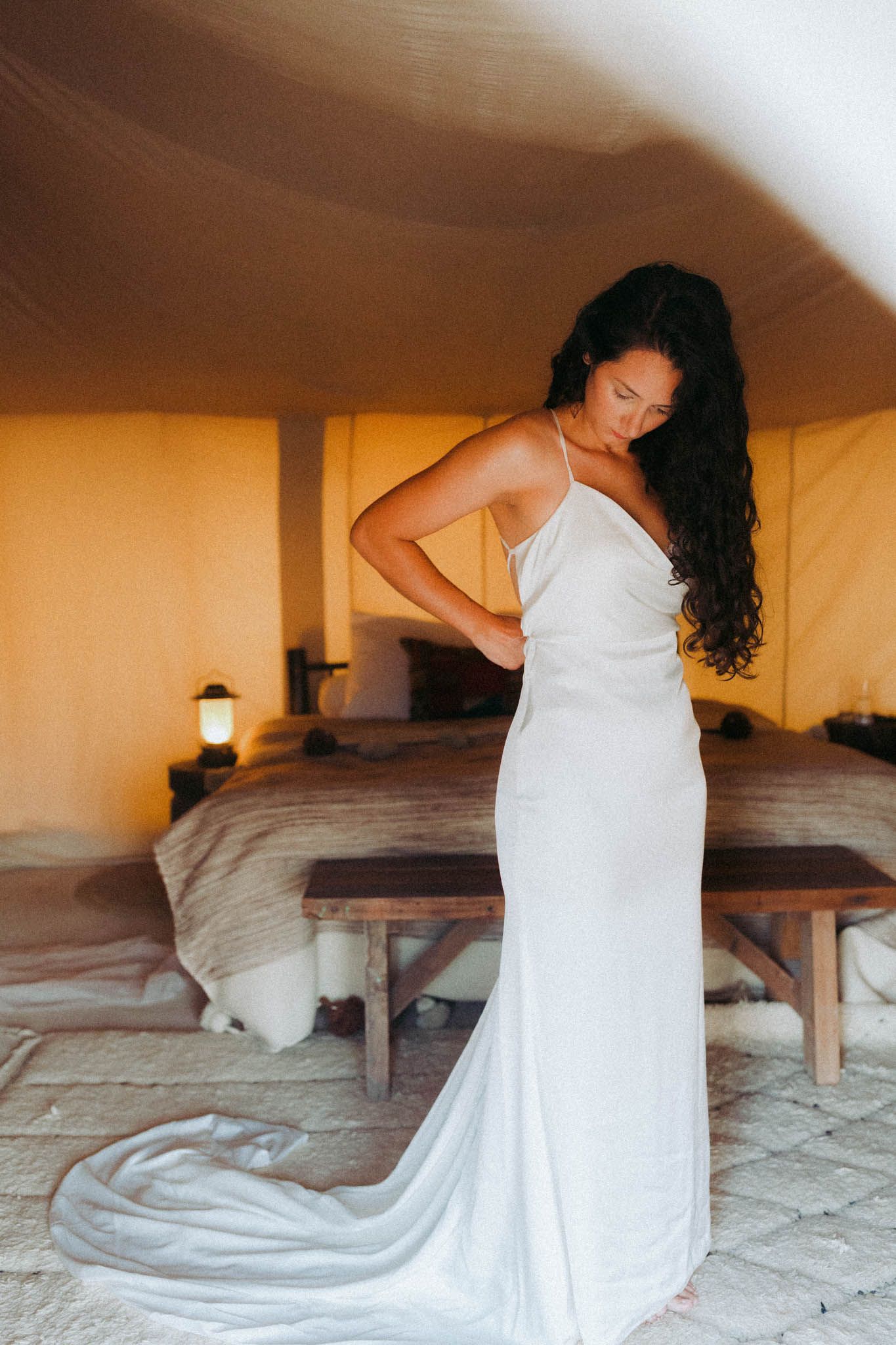 A figure in a flowing white dress poses gracefully on stone steps in a series of artistic bridal portraits.