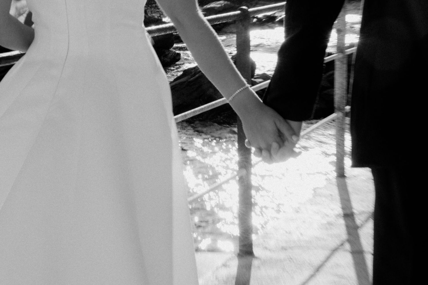 Wedding couple silhouetted against ocean backdrop in romantic seaside ceremony setting.