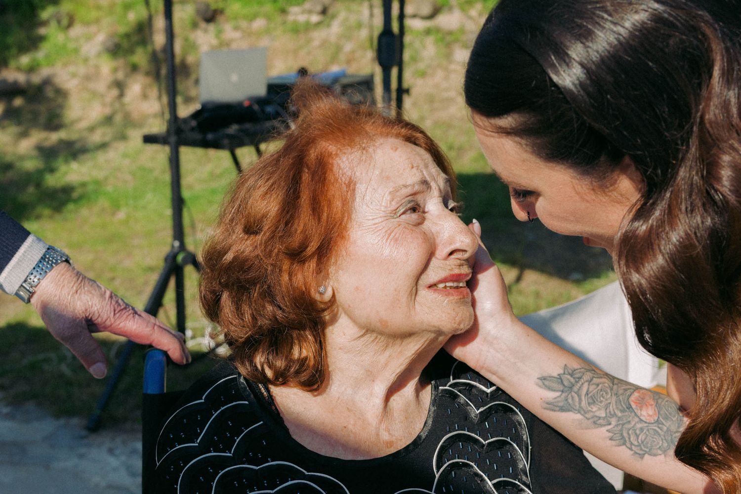 A couple shares an intimate moment outdoors against a natural backdrop.