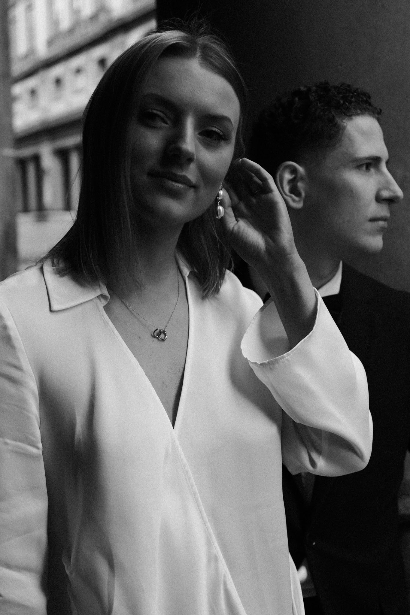 Black and white fashion photo series showing close-up profile portraits in minimalist white clothing against urban backdrop.