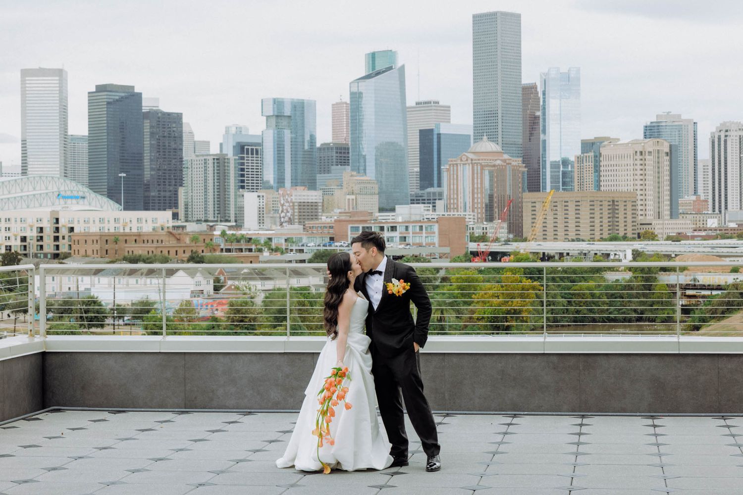 A wedding couple poses for romantic photos on a rooftop terrace with the Chicago skyline as a stunning backdrop.