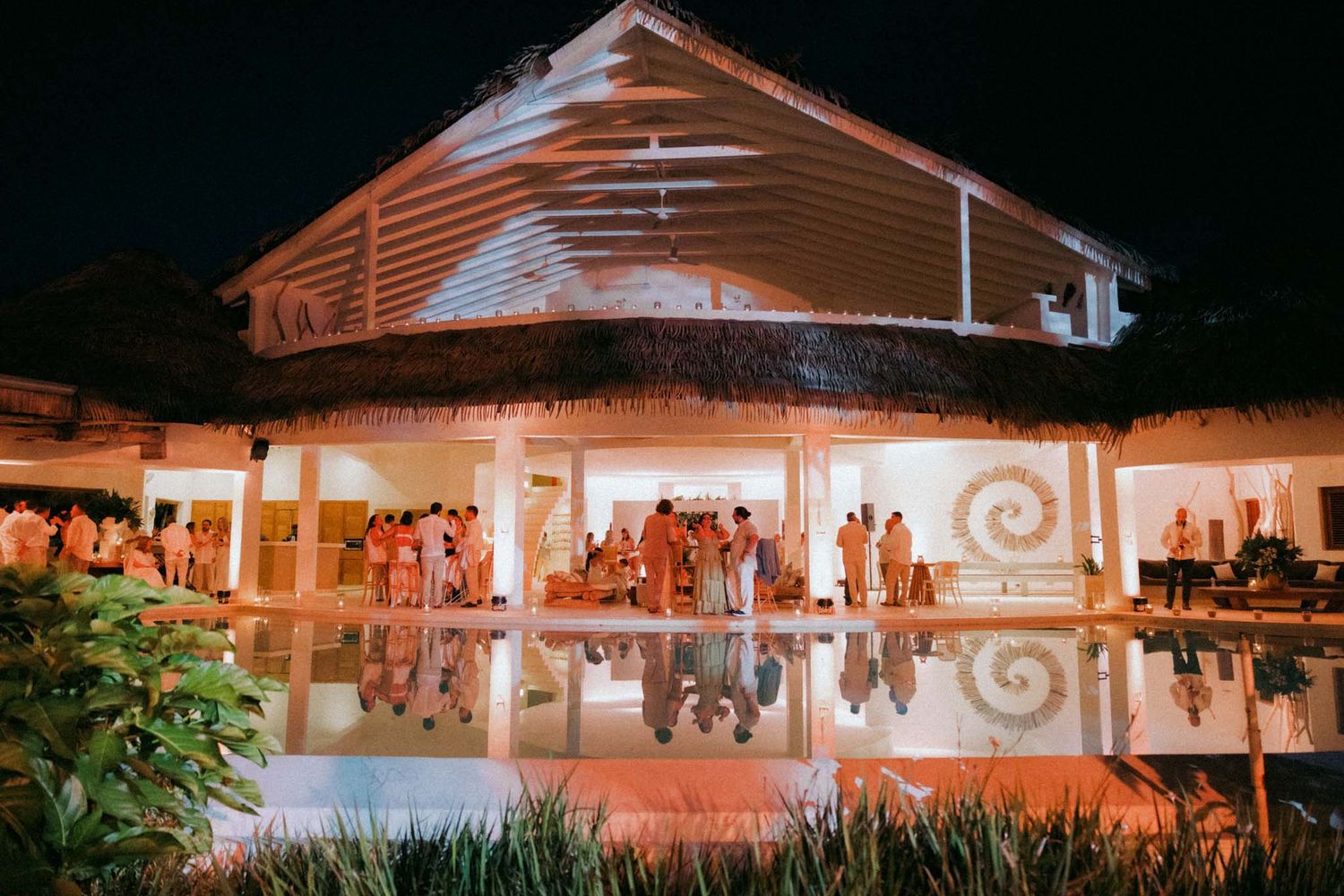 Illuminated white outdoor pavilion with string lights at dusk creates a warm and inviting atmosphere for an evening event.