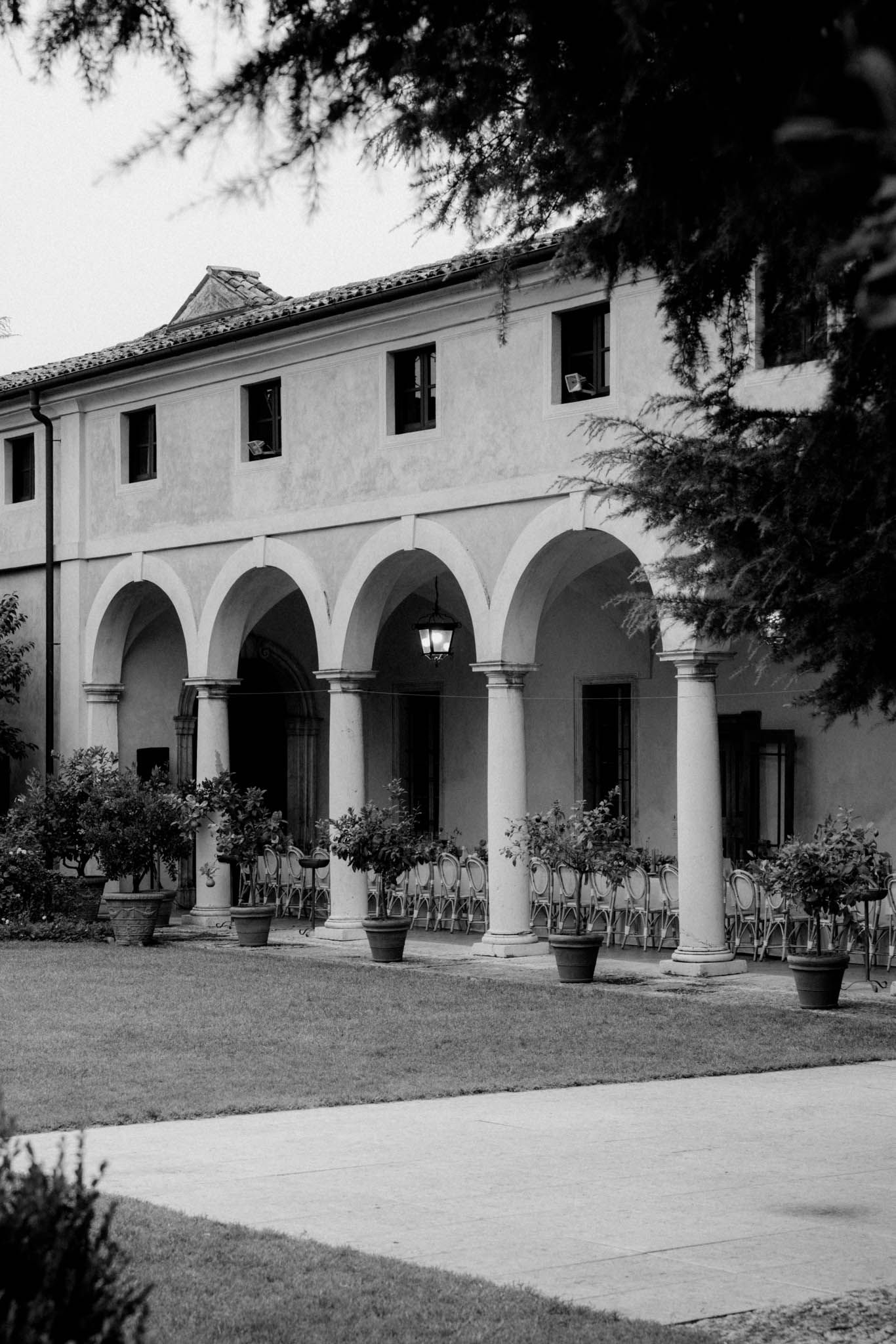 Historic Spanish colonial mission building with white stucco walls and arched colonnade walkway along its facade.