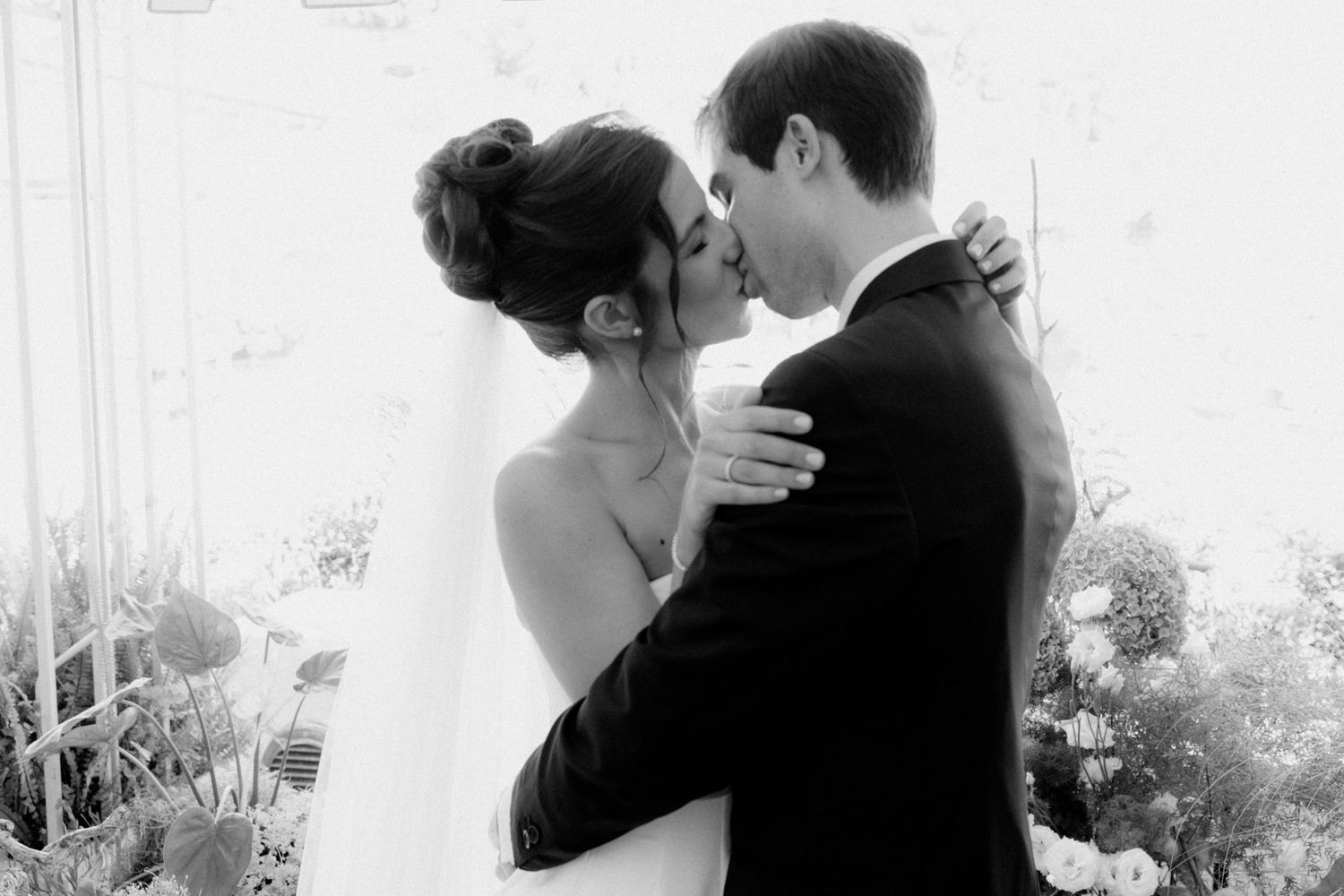 A black and white photo montage shows a couple embracing and kissing in romantic wedding moments.