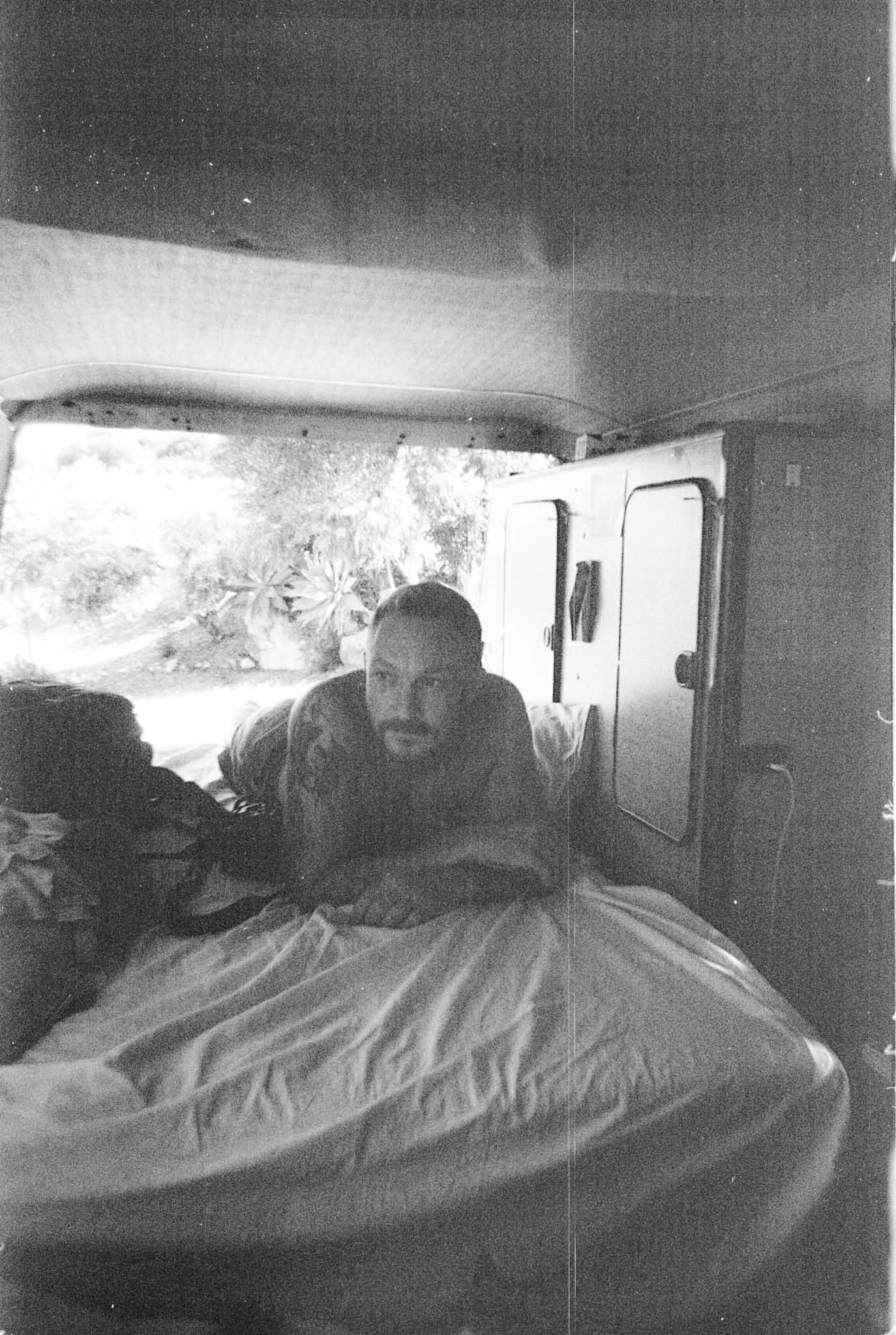 Black and white sequence of photos showing someone sleeping under white bedding in dim lighting.
