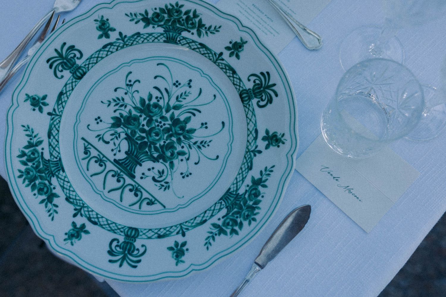 Vintage blue and white porcelain plates with delicate floral patterns displayed in a row.