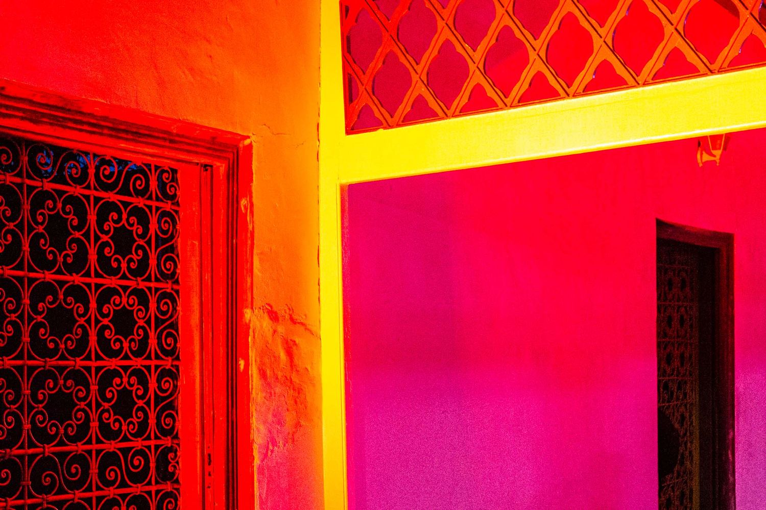 Ornate red and gold architectural details illuminate a hallway with dramatic lighting effects.
