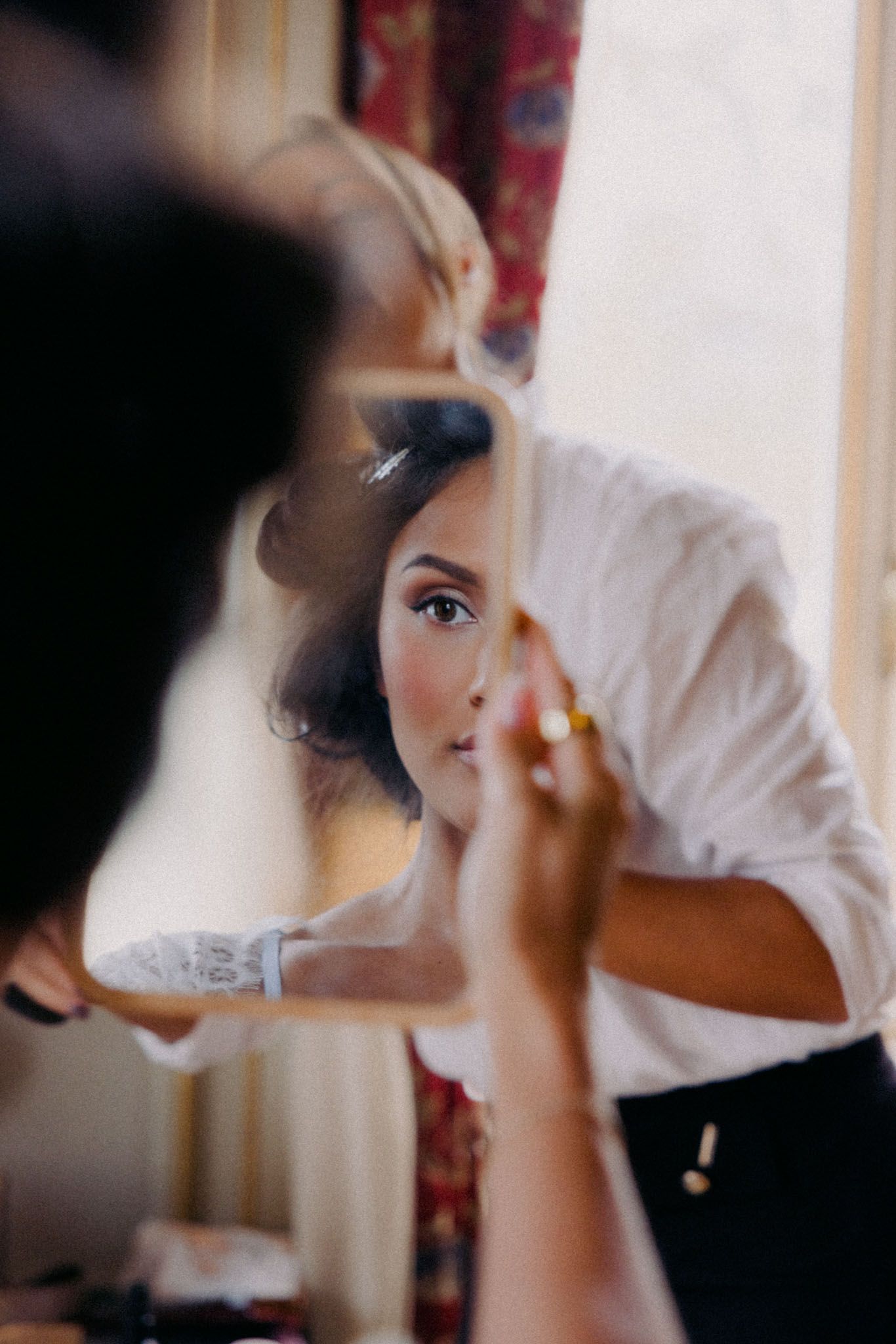 A series of blurred motion shots showing someone applying makeup with a brush in soft natural lighting.