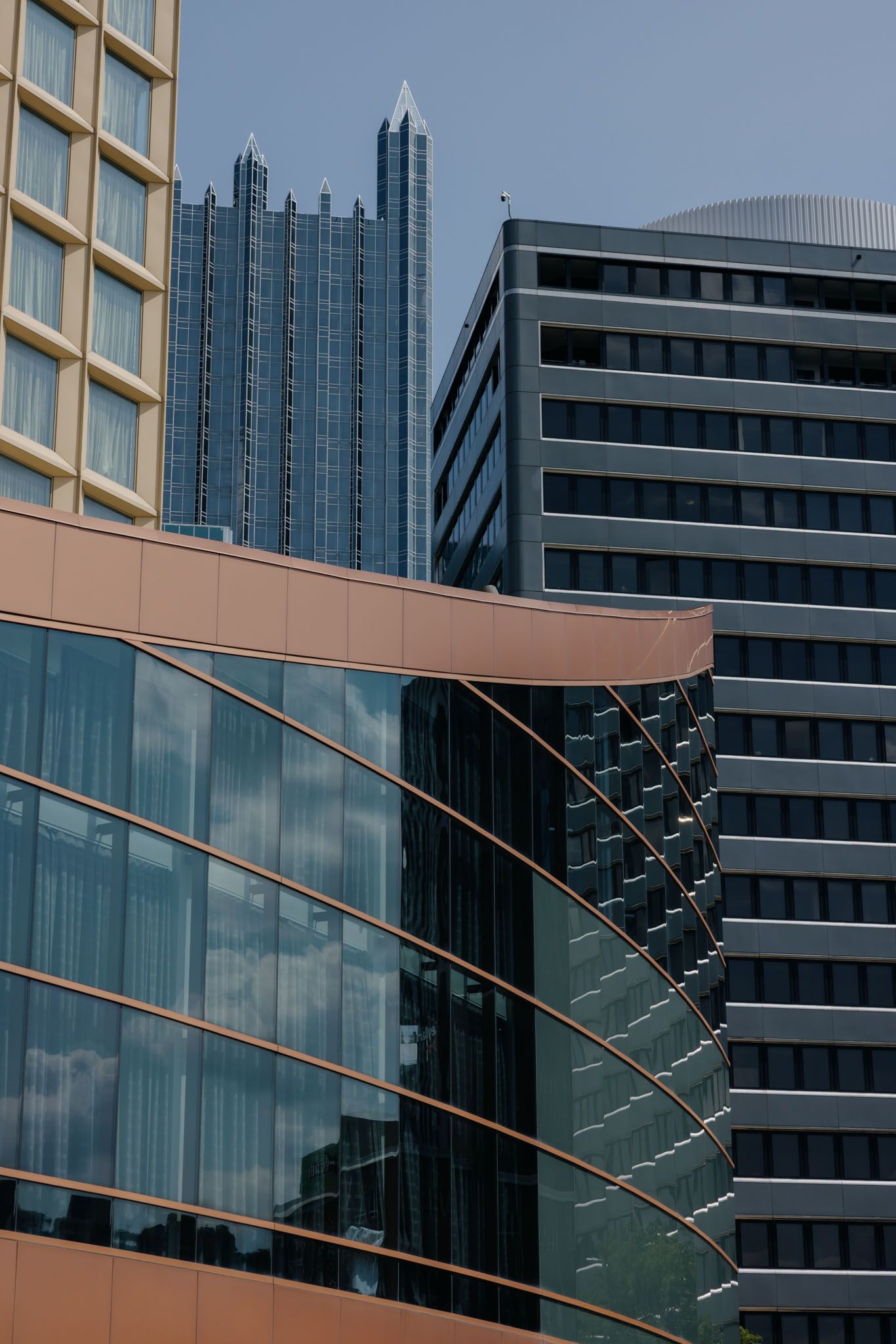 Modern office building exterior with glass windows and architectural details reflecting sunlight and urban surroundings.
