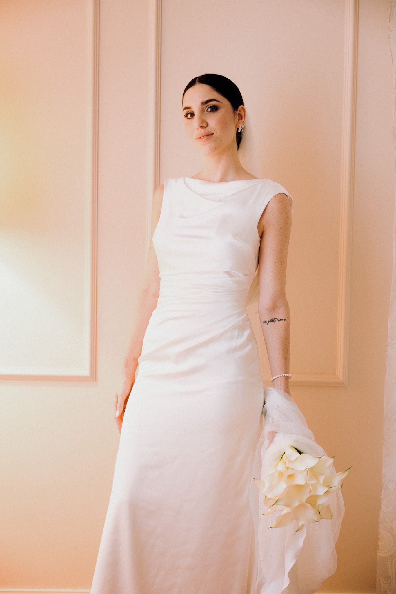 A series of photos showing a pregnant woman in a white dress against a soft pink background.