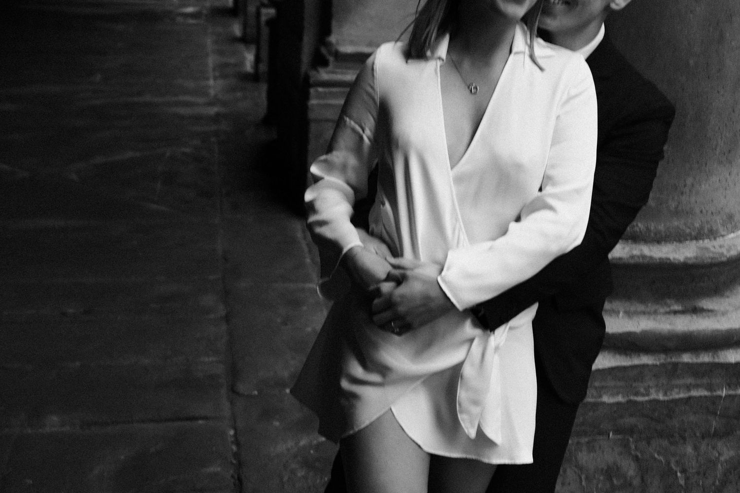 Black and white intimate portrait of a couple embracing, with one person wearing a white blazer.