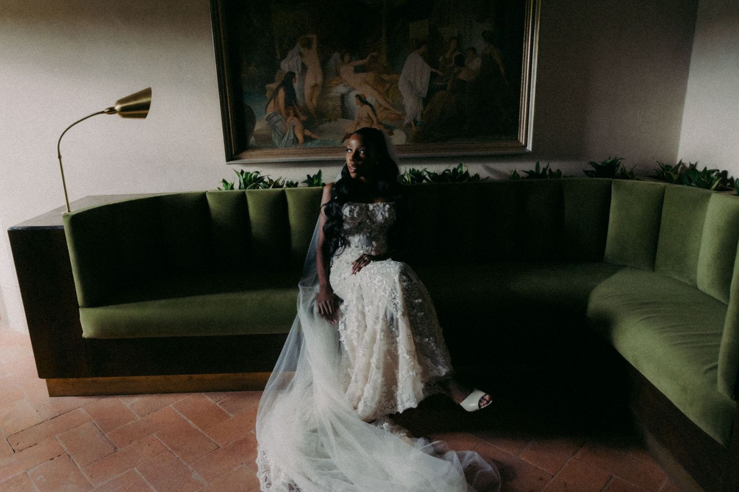 A sequence of wedding dress photos showing the back details and train of a white gown in a dimly lit room.