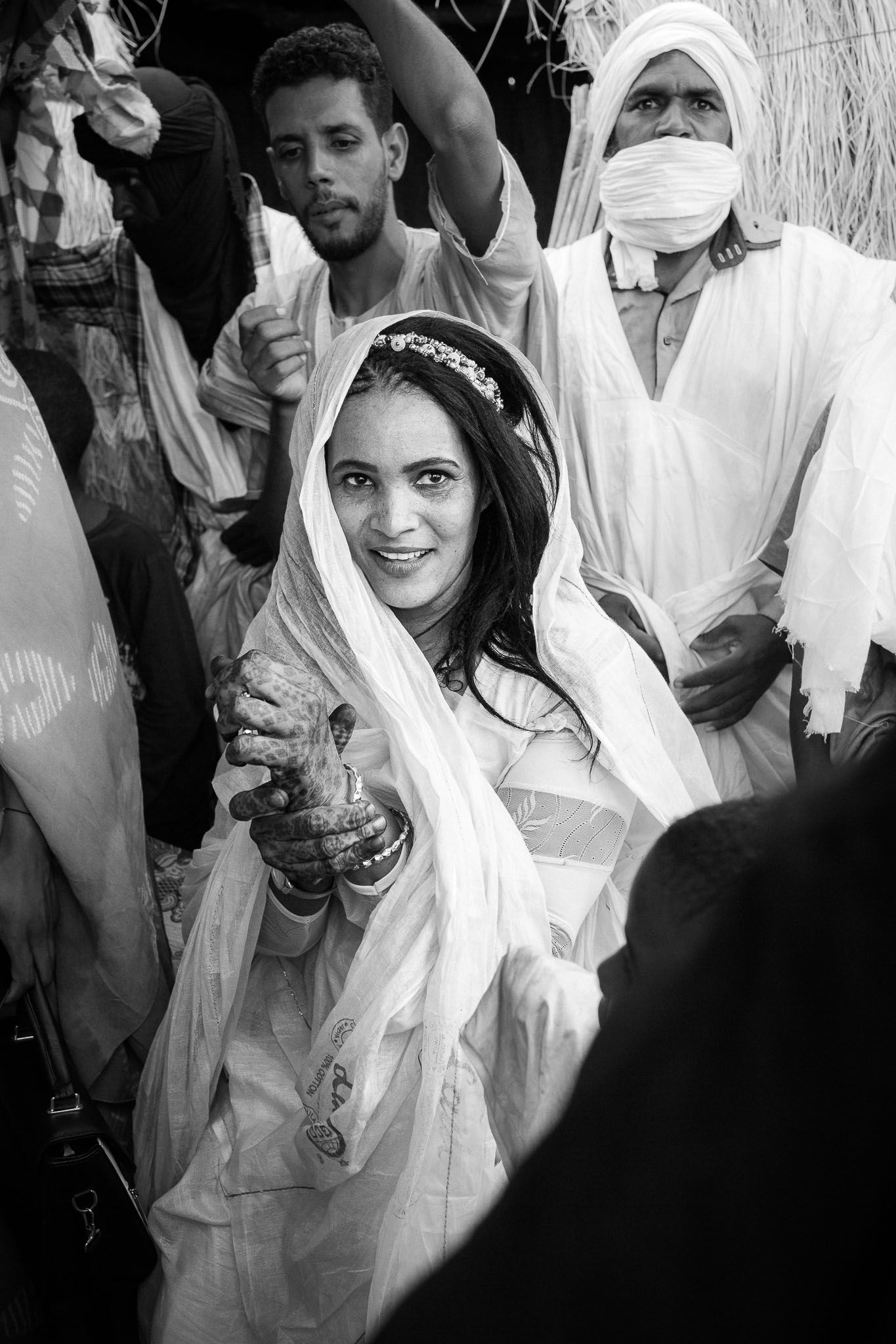 A black and white photo of people in traditional white clothing at what appears to be a cultural celebration.