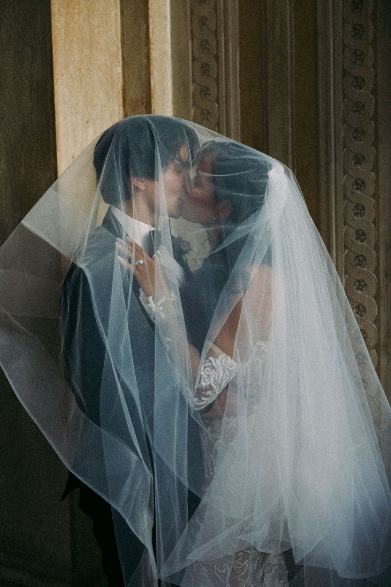 A romantic sequence of wedding photos showing a couple embracing under a flowing white veil in an ornate setting.