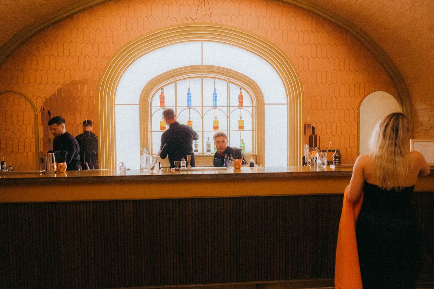 A series of arched windows and vaulted ceilings create a warm orange-tinted architectural interior space.