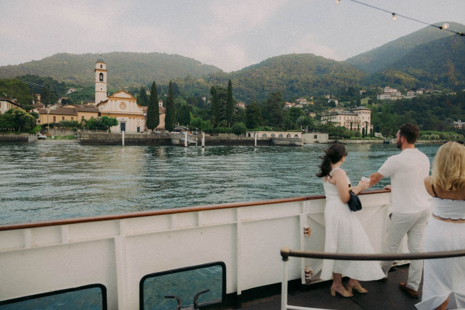 Scenic panoramic view of Lake Como in Italy with mountains and historic buildings along the shoreline.