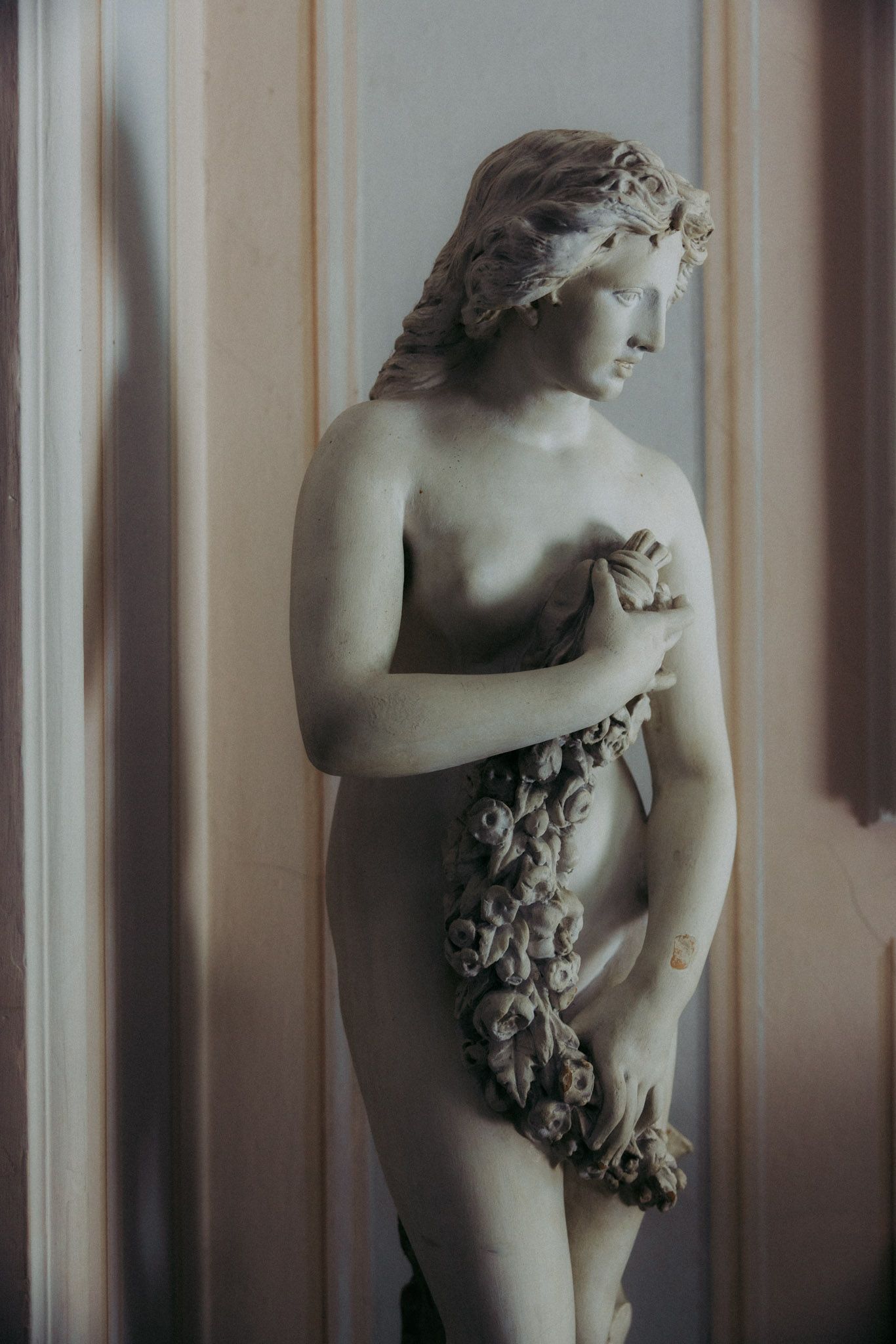 Artistic black and white photograph showing multiple views of a classical marble sculpture against a striped background.