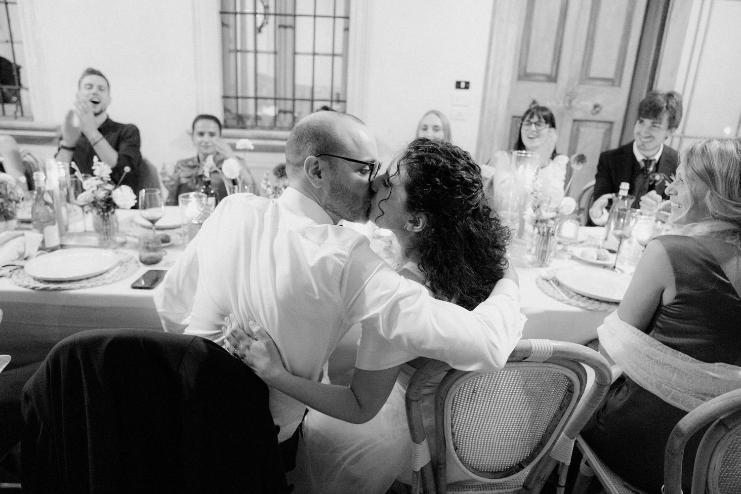 Multiple candid shots of guests dancing and celebrating at a formal event in black and white photography.