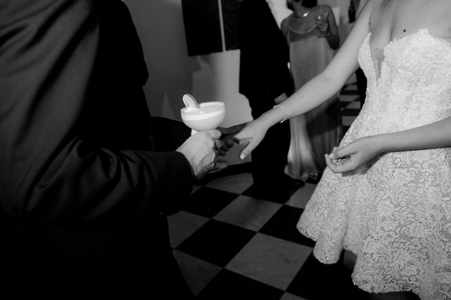 A couple shares a romantic dance together on a black and white checkered dance floor at their wedding reception.