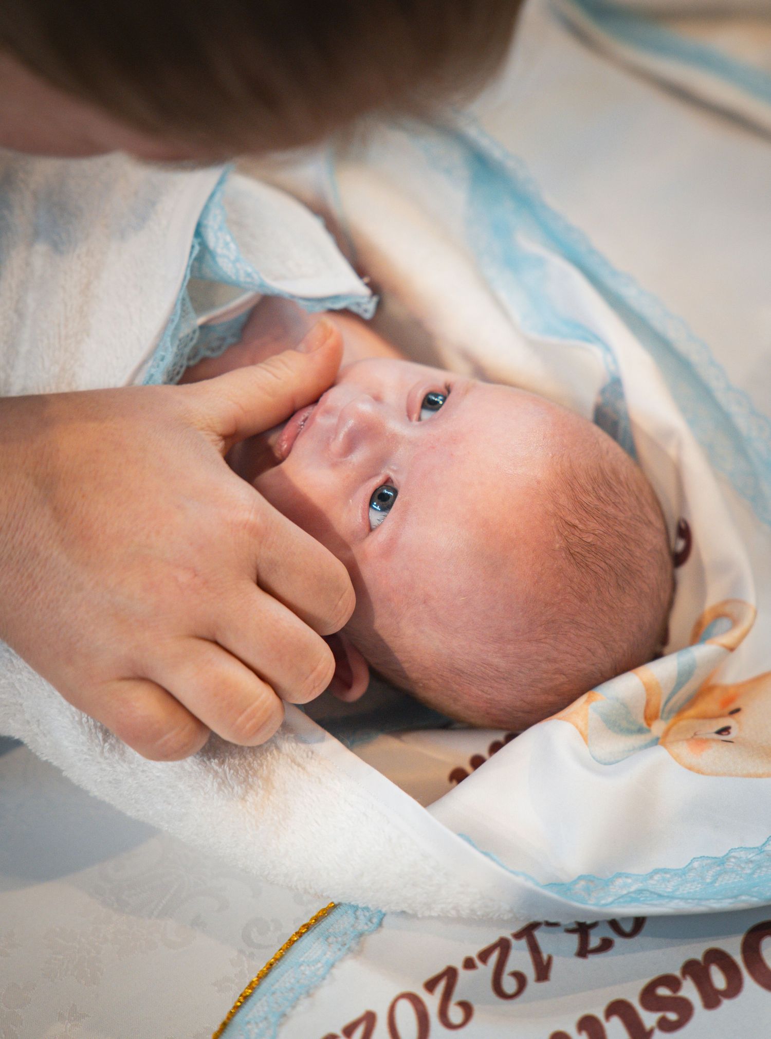 Un bébé et sa maman durant un baptême