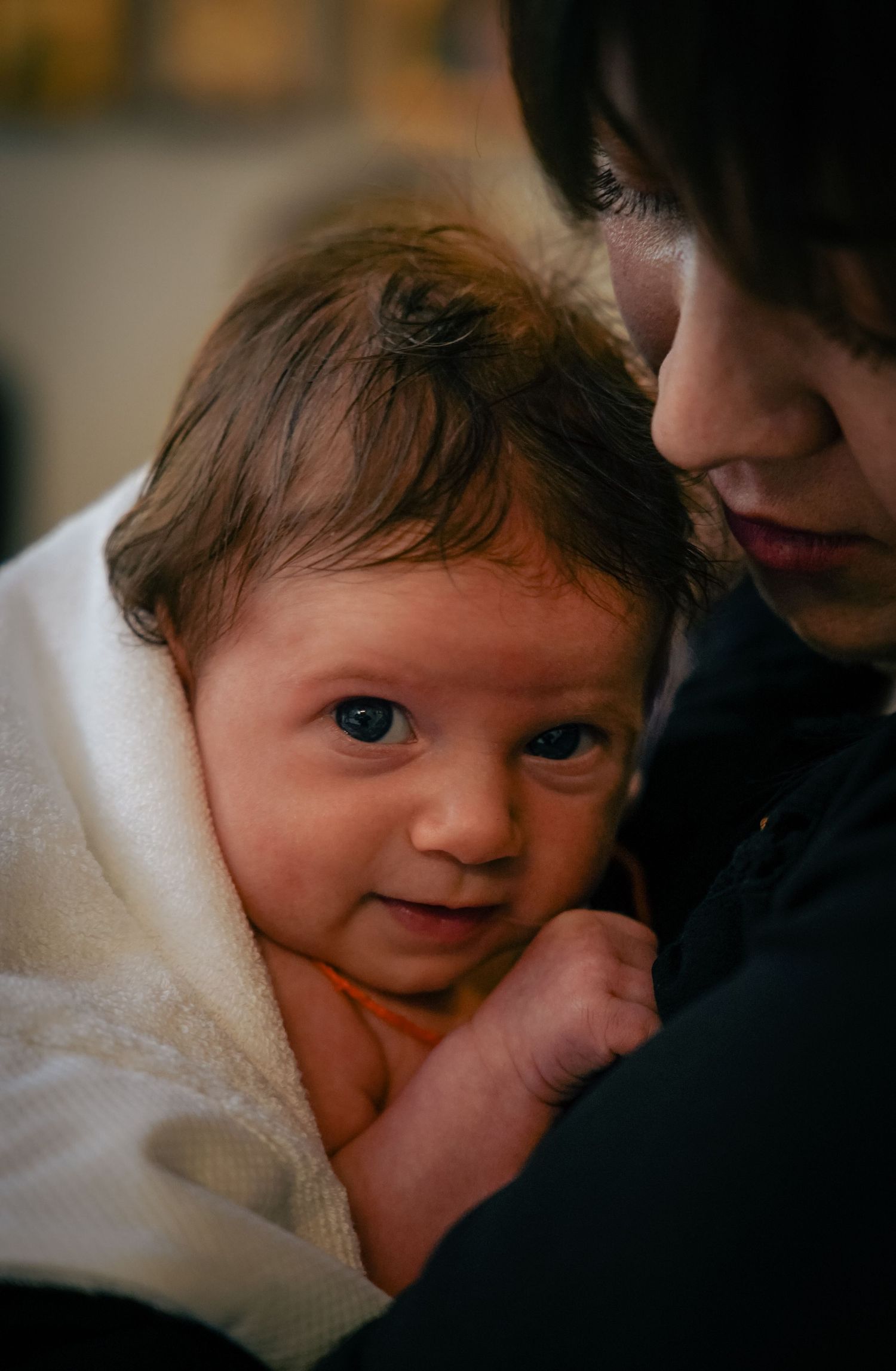 Une mère et son fils durant un baptême.