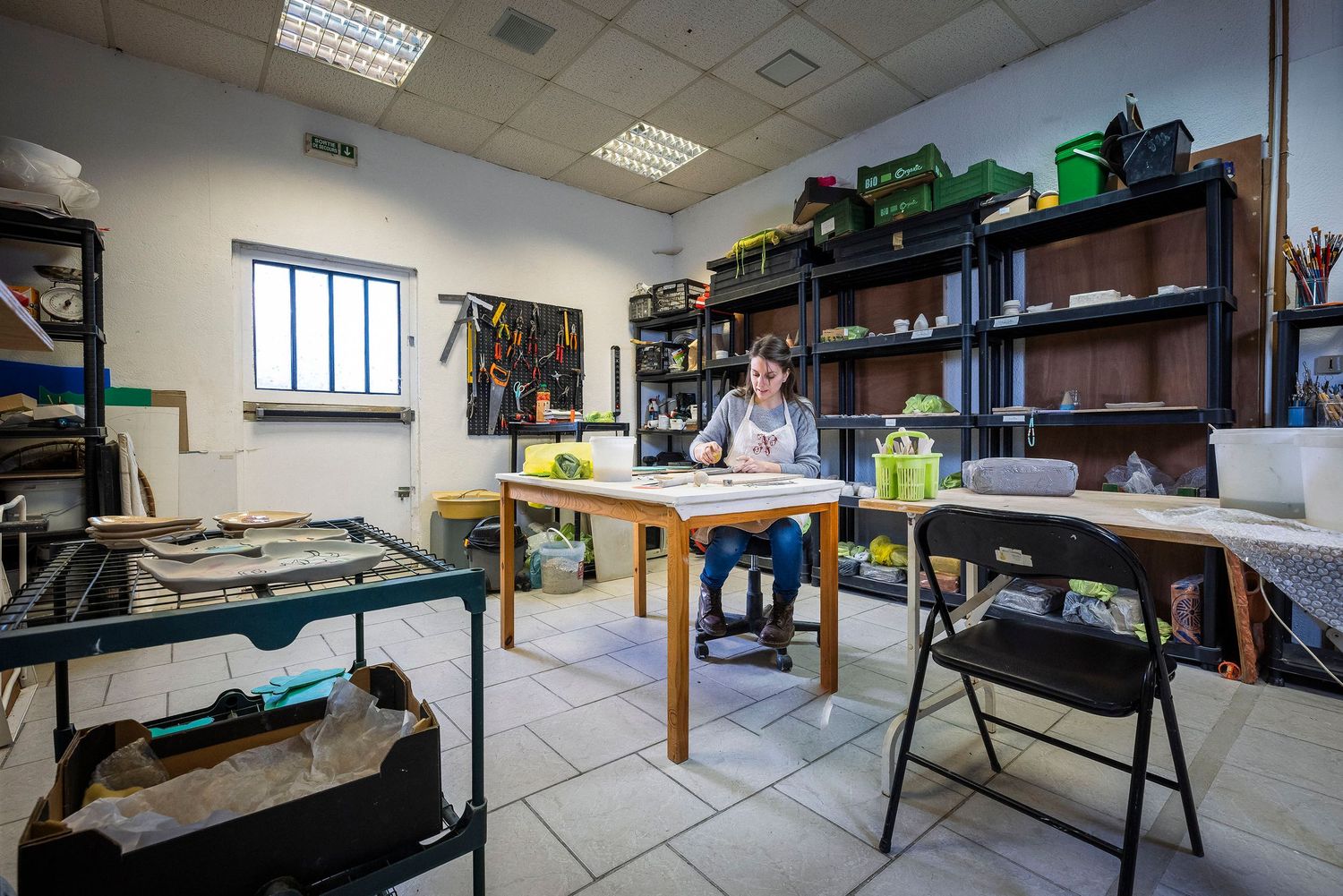 Bright office space with bookshelves, work table and natural lighting. Claire Bourguin Bourgain Bourgoin Bourquin - Photographe Bruxelles Be