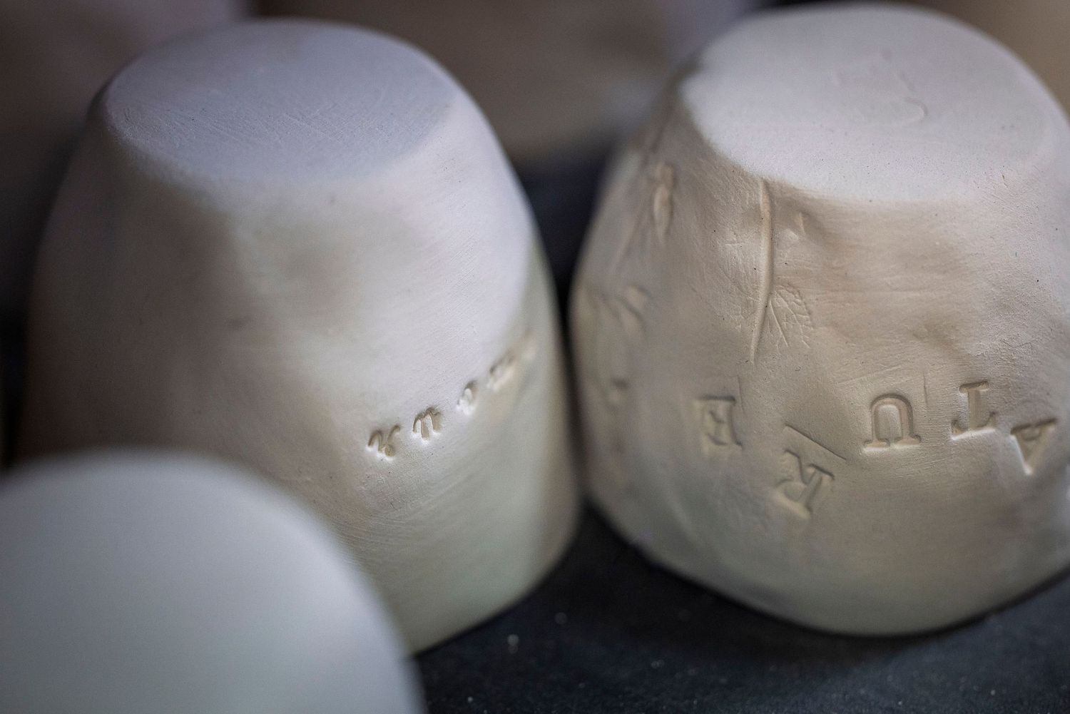 Close-up of white ceramic molds with textured surfaces and markings.Claire Bourguin Bourgain Bourgoin Bourquin - Photographe Bruxelles Belgi