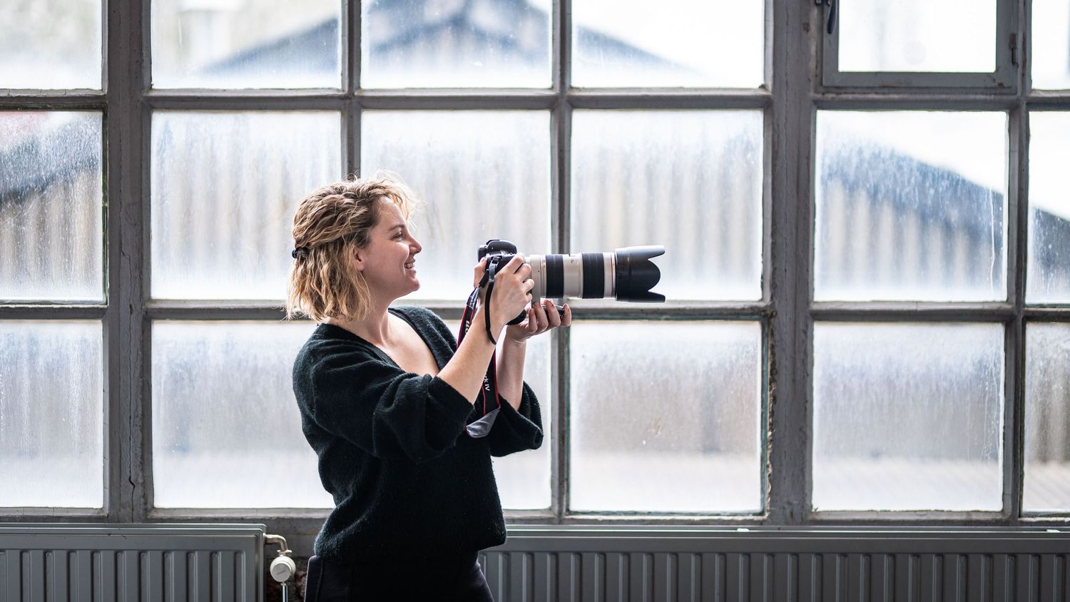 Panoramic view of photographers shooting through windows in winter landscape.