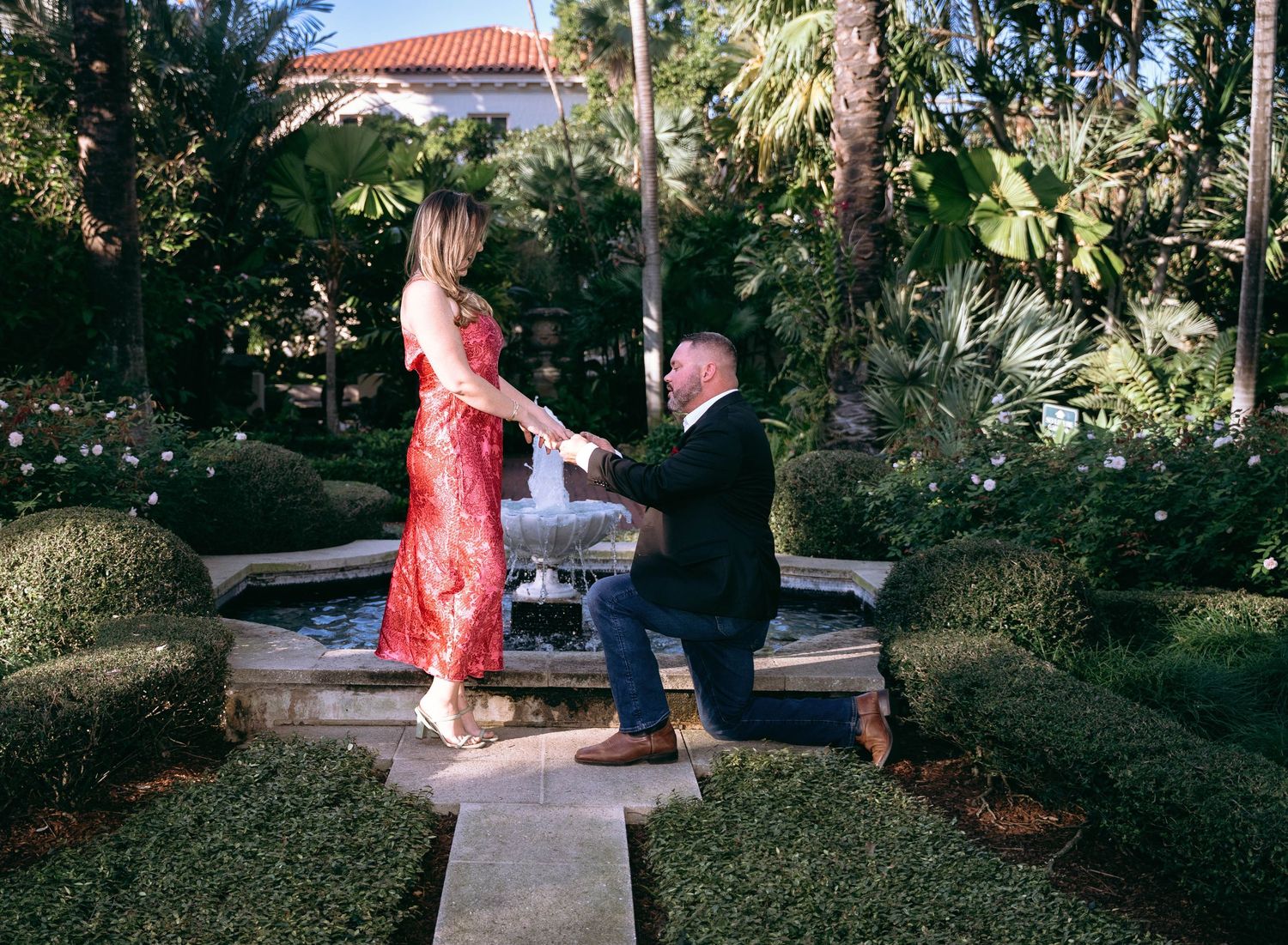Romantic couple sharing intimate moments in a lush garden setting during a photo session.
