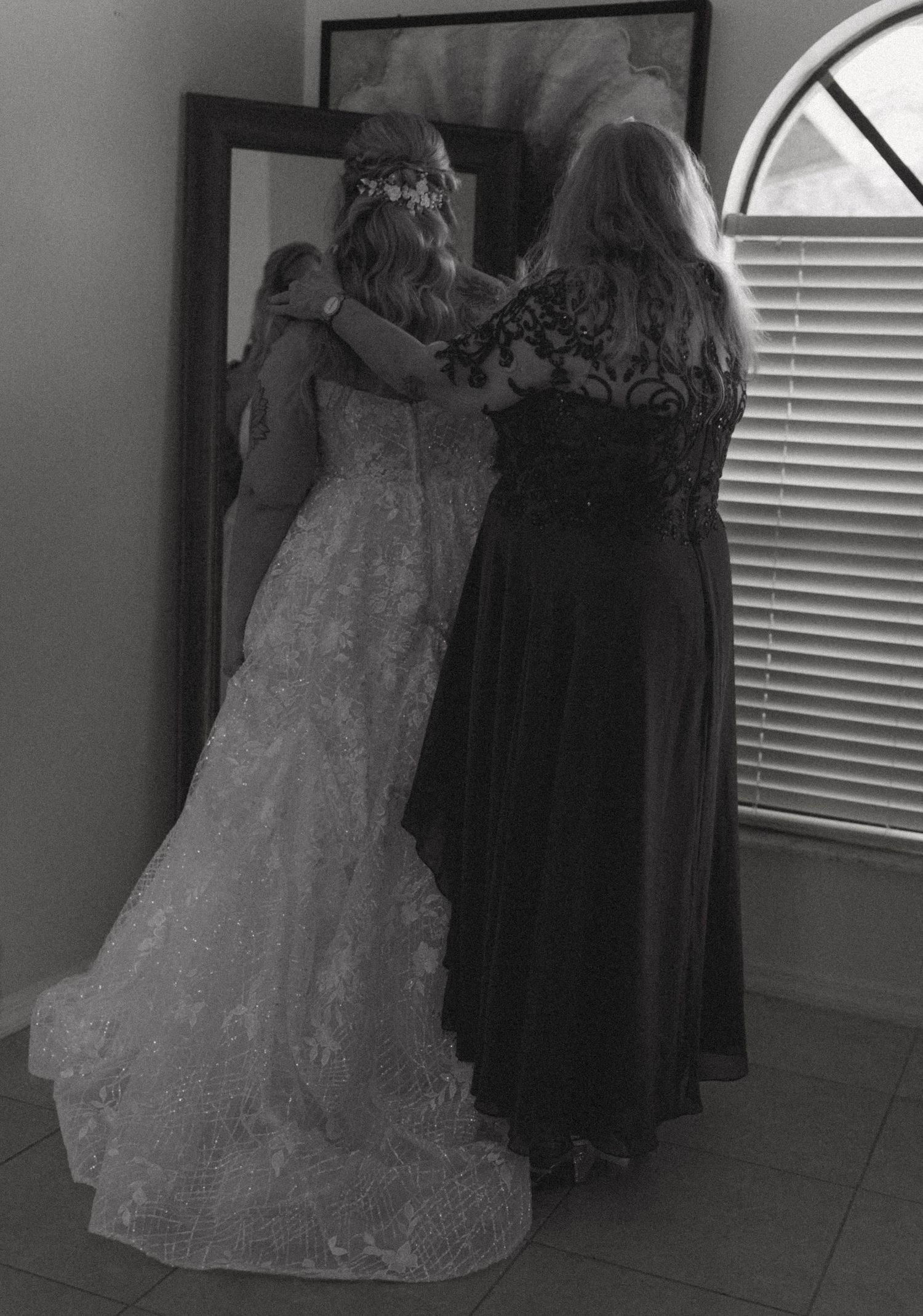 Wedding dress detail shot with black and white filter showing lace texture.