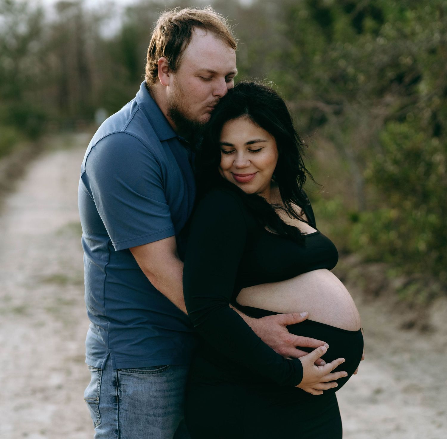 A couple shares an intimate embrace on a beach during a romantic photoshoot.