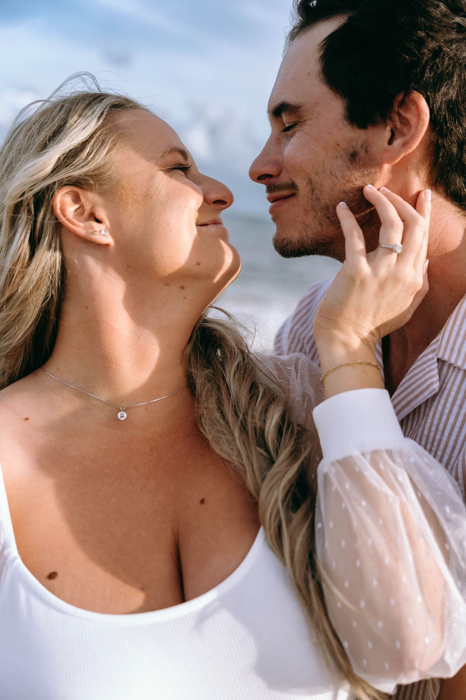Close-up shots of a romantic couple in white outfits against a bright background.