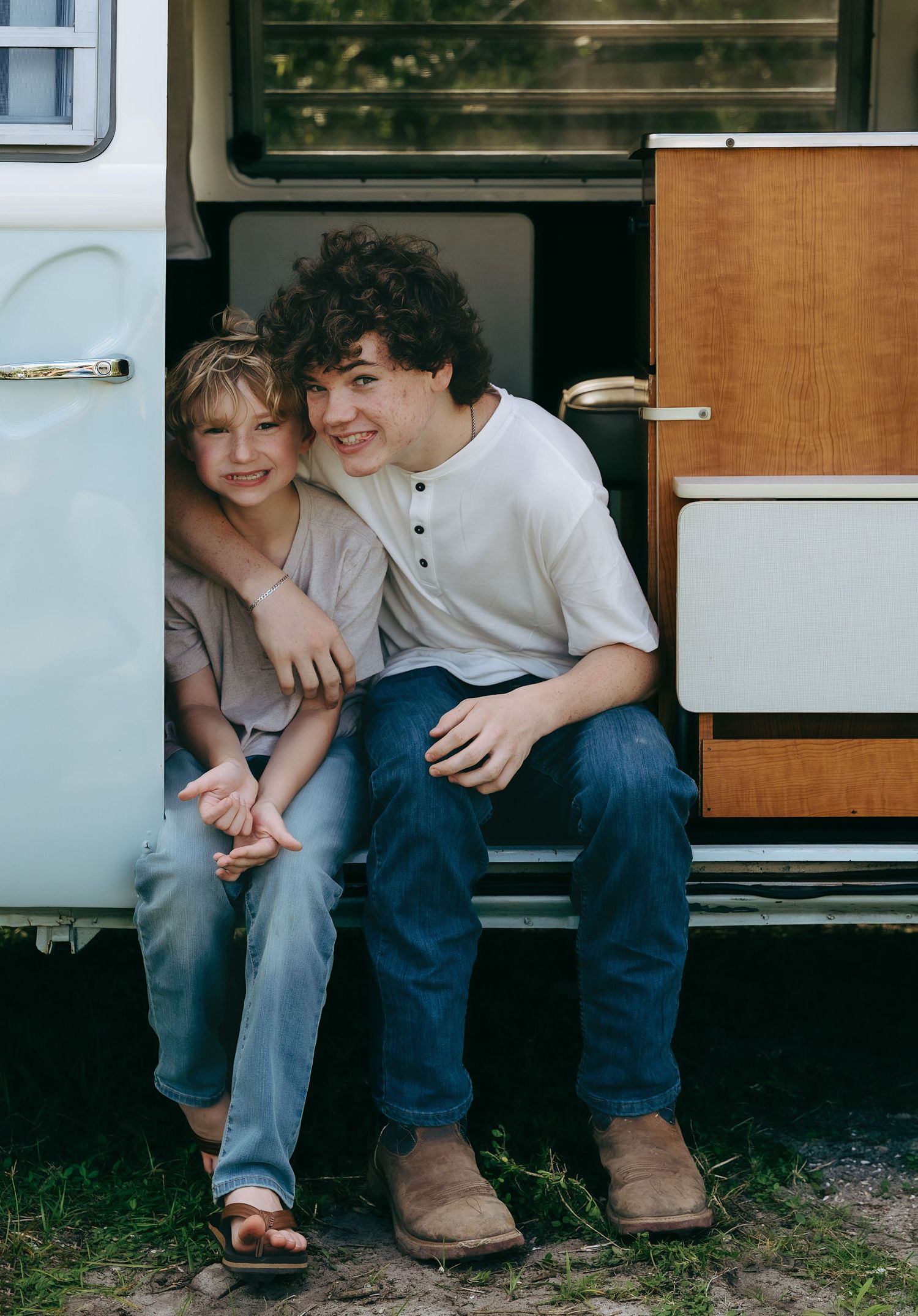 Casual scene at the entrance of a vintage camper van with wooden interior details.