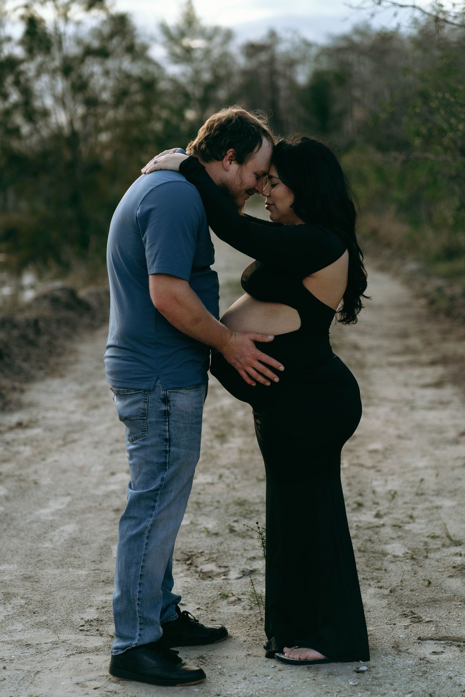 A couple shares intimate moments in a series of black and white photos against a natural outdoor backdrop.